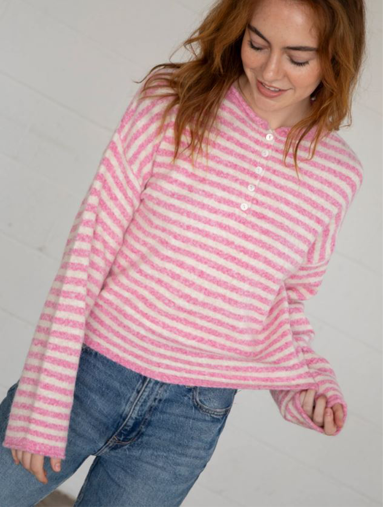 Model wearing Things Between Striped Henley Pullover Sweater featuring a striped design, button closure, and rolled hem.